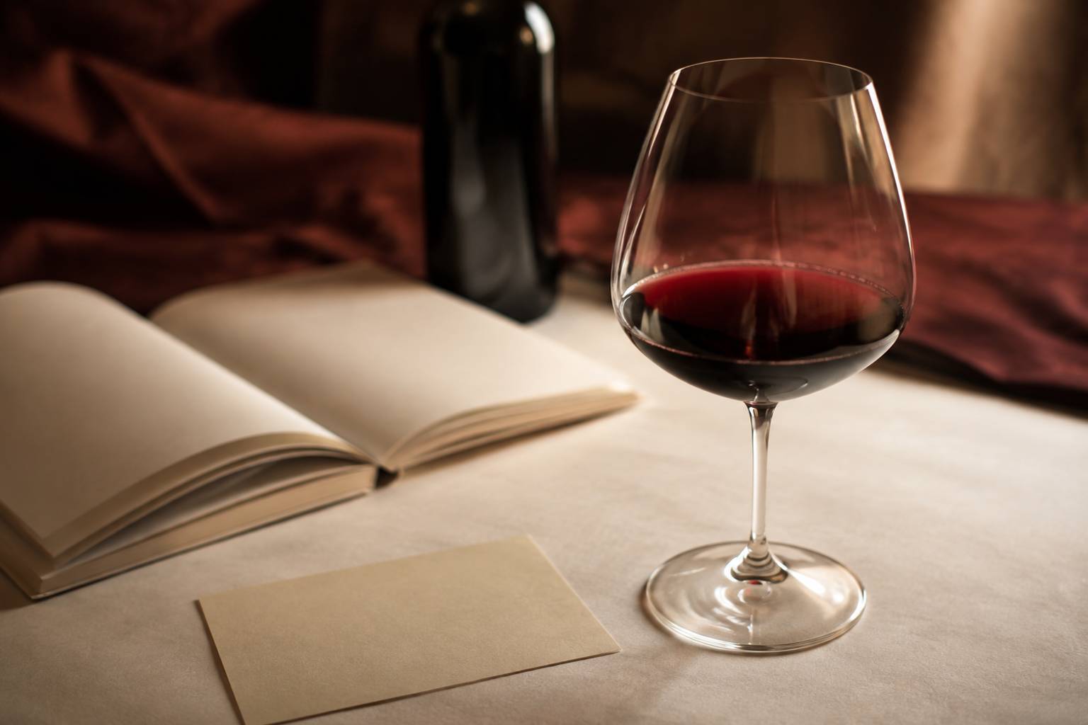 Verre de vin rouge à robe violine devant une bouteille générique